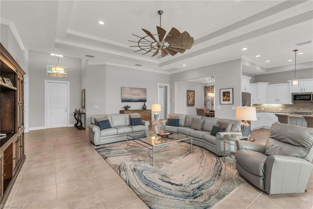 14812 Dockside Lane Naples, FL 34114 - Photo 9 of 49 a living room with furniture a large window and a flat screen tv