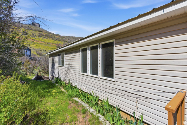 380 Luzern Road Midway, UT 84049 - Photo 58 of 74 Exterior siding featuring multiple windows with white trim, a gabled roofline, and a natural landscape surrounding the property