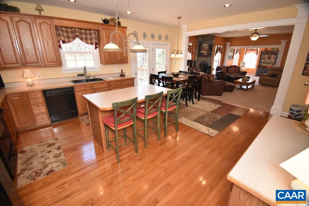 285 March Road Stanardsville, VA 22973 - Photo 69 of 75 a dining hall with granite countertop a stove top oven a dining table and chairs with wooden floor