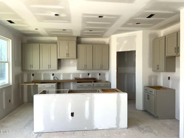 a kitchen with kitchen island a counter top space a sink stainless steel appliances and cabinets