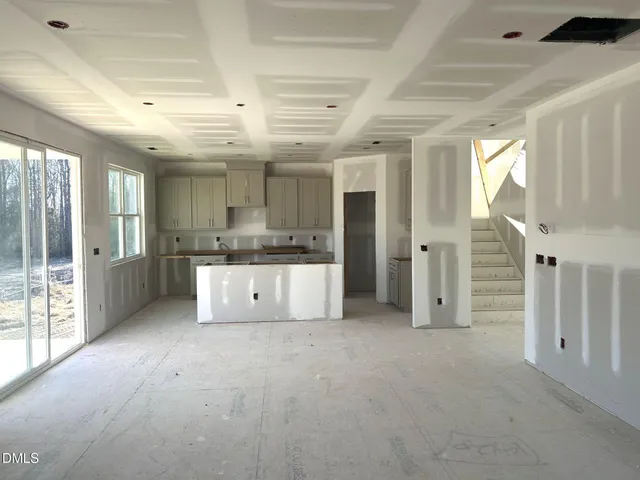 a large room with stainless steel appliances kitchen island granite countertop a refrigerator and a sink