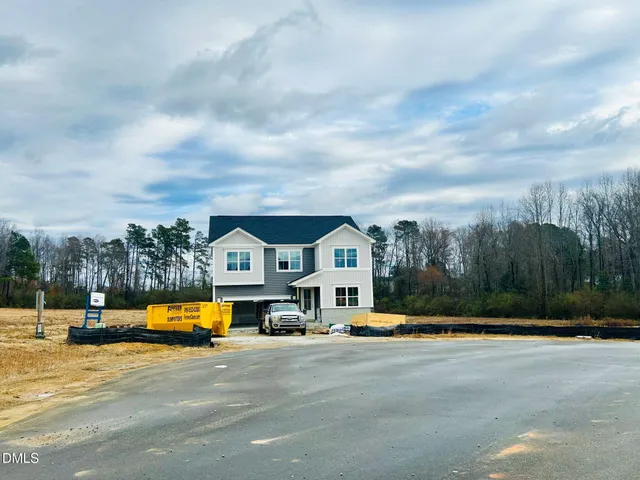 a view of a white house with a big yard and large trees