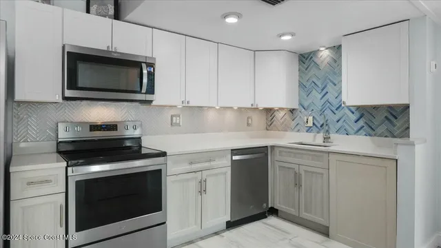 a kitchen with white cabinets and stainless steel appliances