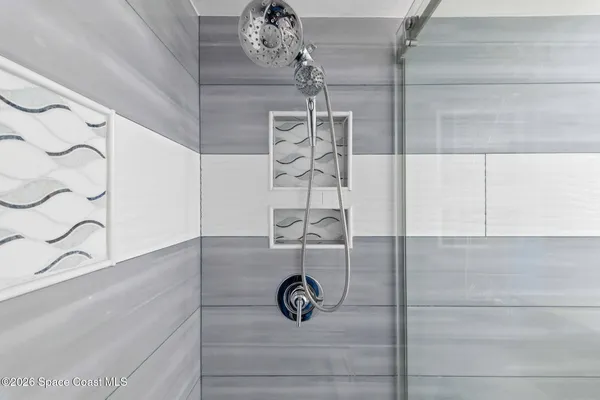 a bathroom with a shower and mirror