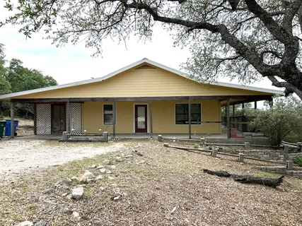 a front view of a house with yard tree and wooden fence
