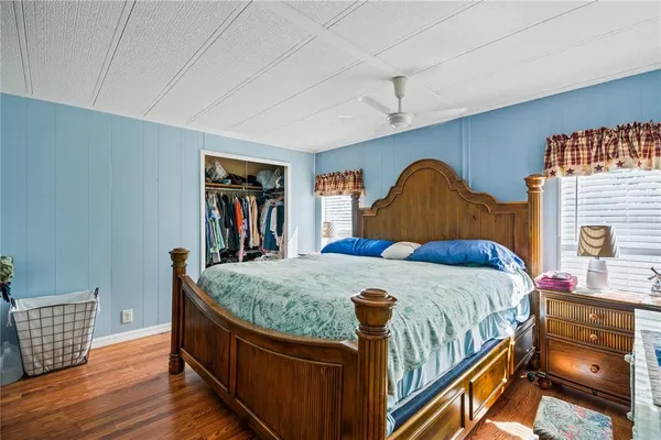 a bedroom with bed and wooden floor
