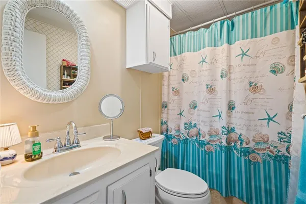 a bathroom with a sink vanity mirror and toilet