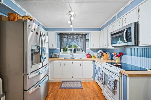 a kitchen with stainless steel appliances granite countertop a refrigerator a stove and a sink