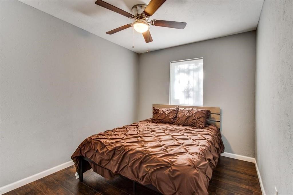 9645 Limestone Drive Dallas, TX 75217 - Photo 12 of 15 a bedroom with a bed and a chandelier