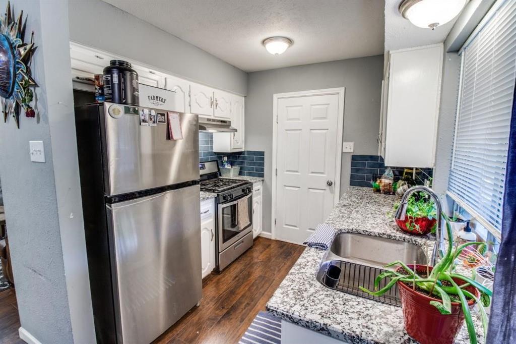 9645 Limestone Drive Dallas, TX 75217 - Photo 4 of 15 a kitchen with stainless steel appliances granite countertop a refrigerator a stove a sink a dining table and chairs