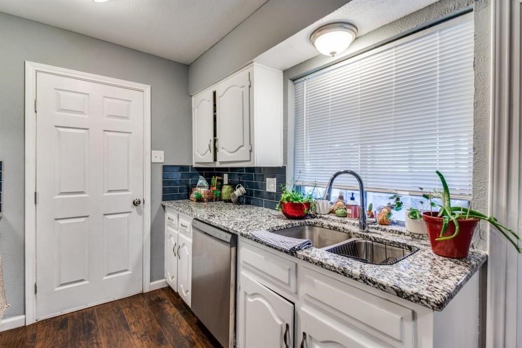 9645 Limestone Drive Dallas, TX 75217 - Photo 5 of 15 a kitchen with stainless steel appliances granite countertop white cabinets a stove and a window