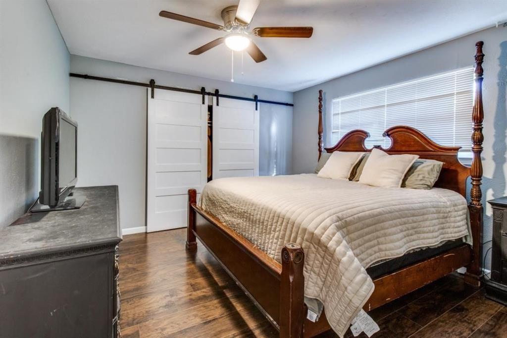 9645 Limestone Drive Dallas, TX 75217 - Photo 6 of 15 a bedroom with a large bed and a flat tv screen on dresser