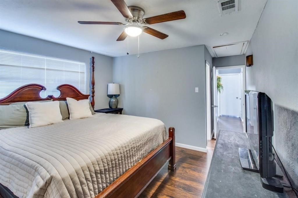 9645 Limestone Drive Dallas, TX 75217 - Photo 7 of 15 a bedroom with a large bed and a chandelier