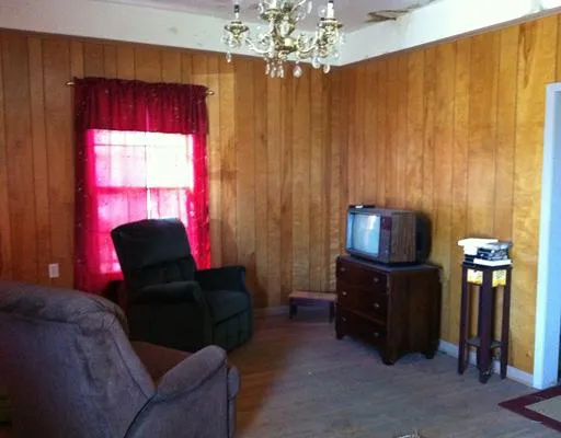 a living room with furniture a chandelier and a window