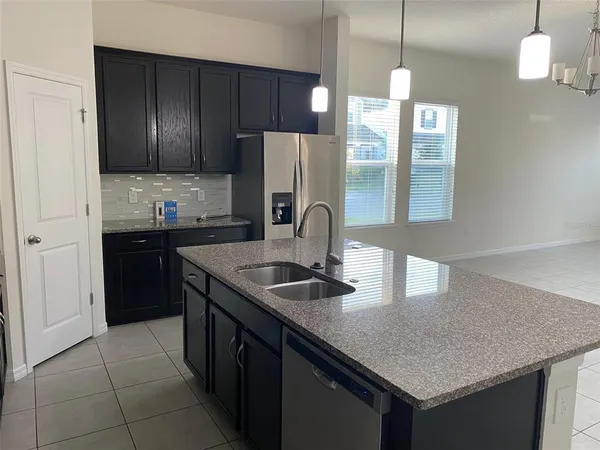 a kitchen with granite countertop a refrigerator a stove and a sink