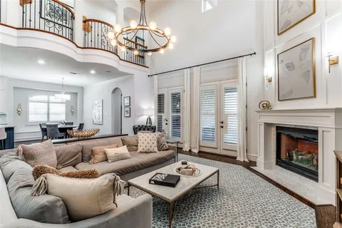 a living room with furniture a chandelier and a fireplace
