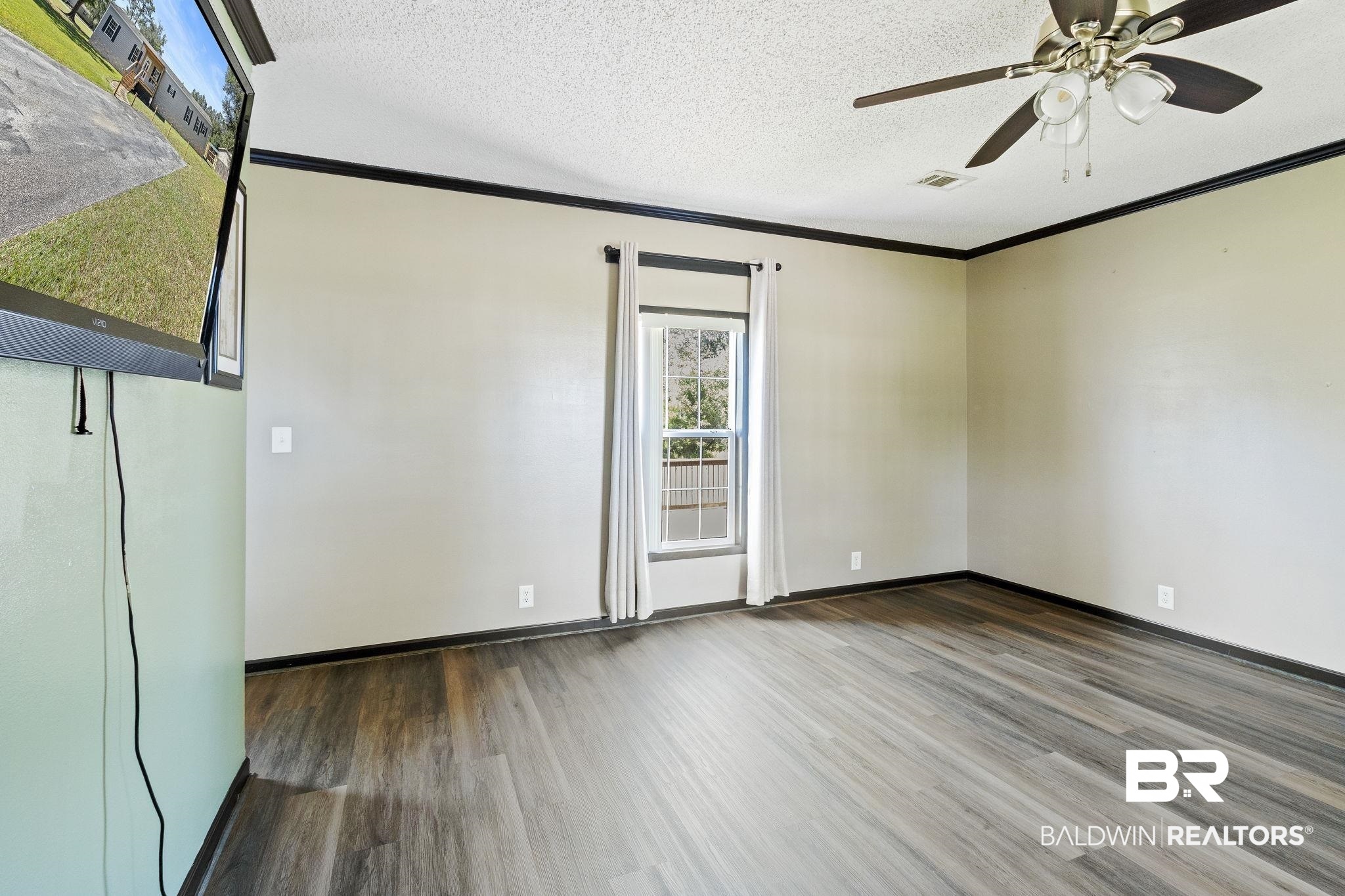 6870 Cecilia Court Theodore, AL 36582 - Photo 50 of 83 Spare room featuring ornamental molding, hardwood / wood-style flooring, ceiling fan, and a textured ceiling