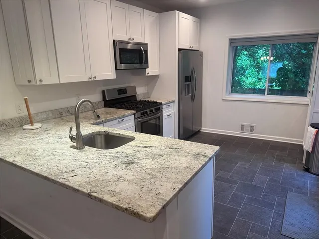 a kitchen with cabinets stainless steel appliances and a sink