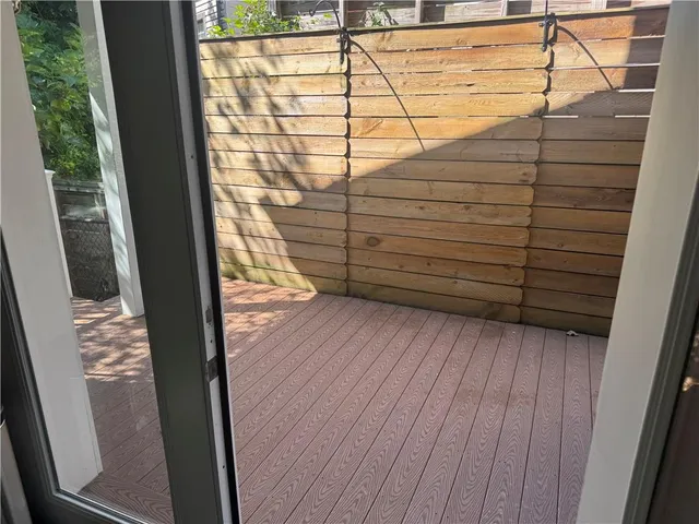 a view of a porch with a floor to ceiling window and wooden floor