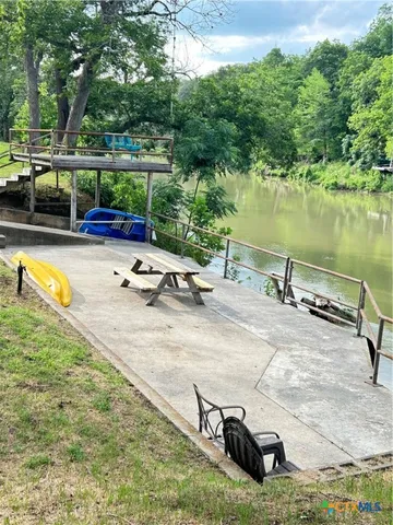 a view of a swimming pool with a patio and a yard