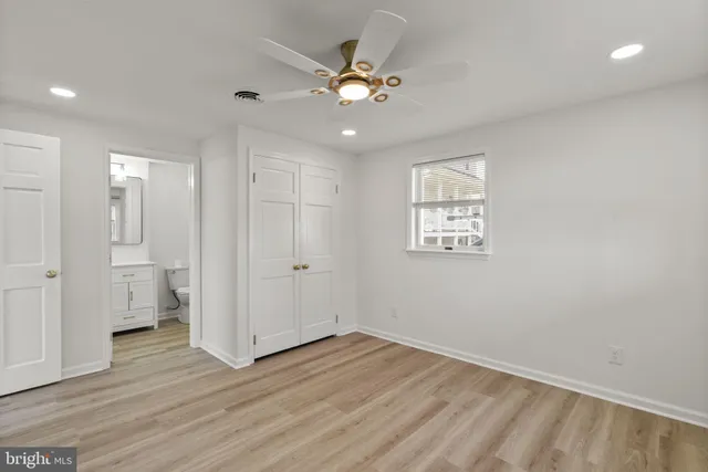 a view of a big room with wooden floor and chandelier fan