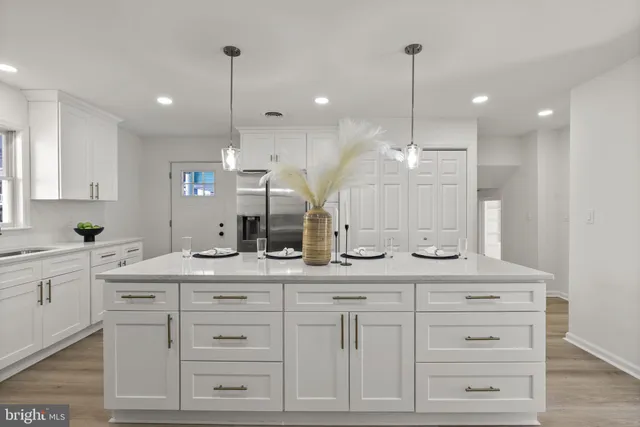 a kitchen with kitchen island white cabinets and white appliances