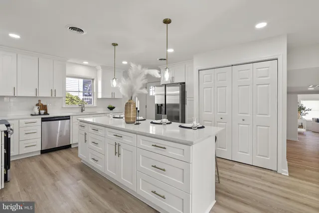 a kitchen with kitchen island granite countertop a sink cabinets and wooden floor