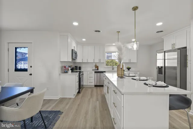 a kitchen with a sink a counter top space stainless steel appliances and cabinets
