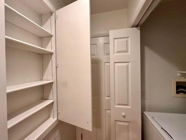 a view of walk in closet with empty racks