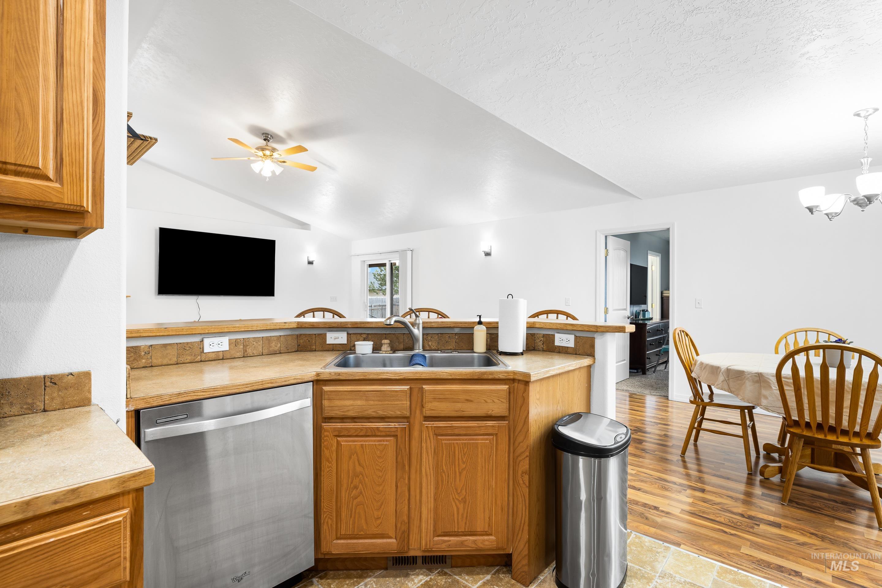 191 Southwest Quaker Drive Mountain Home, ID 83647 - Photo 19 of 43 Kitchen featuring brown cabinets, dishwasher, a peninsula, light countertops, and light wood finished floors