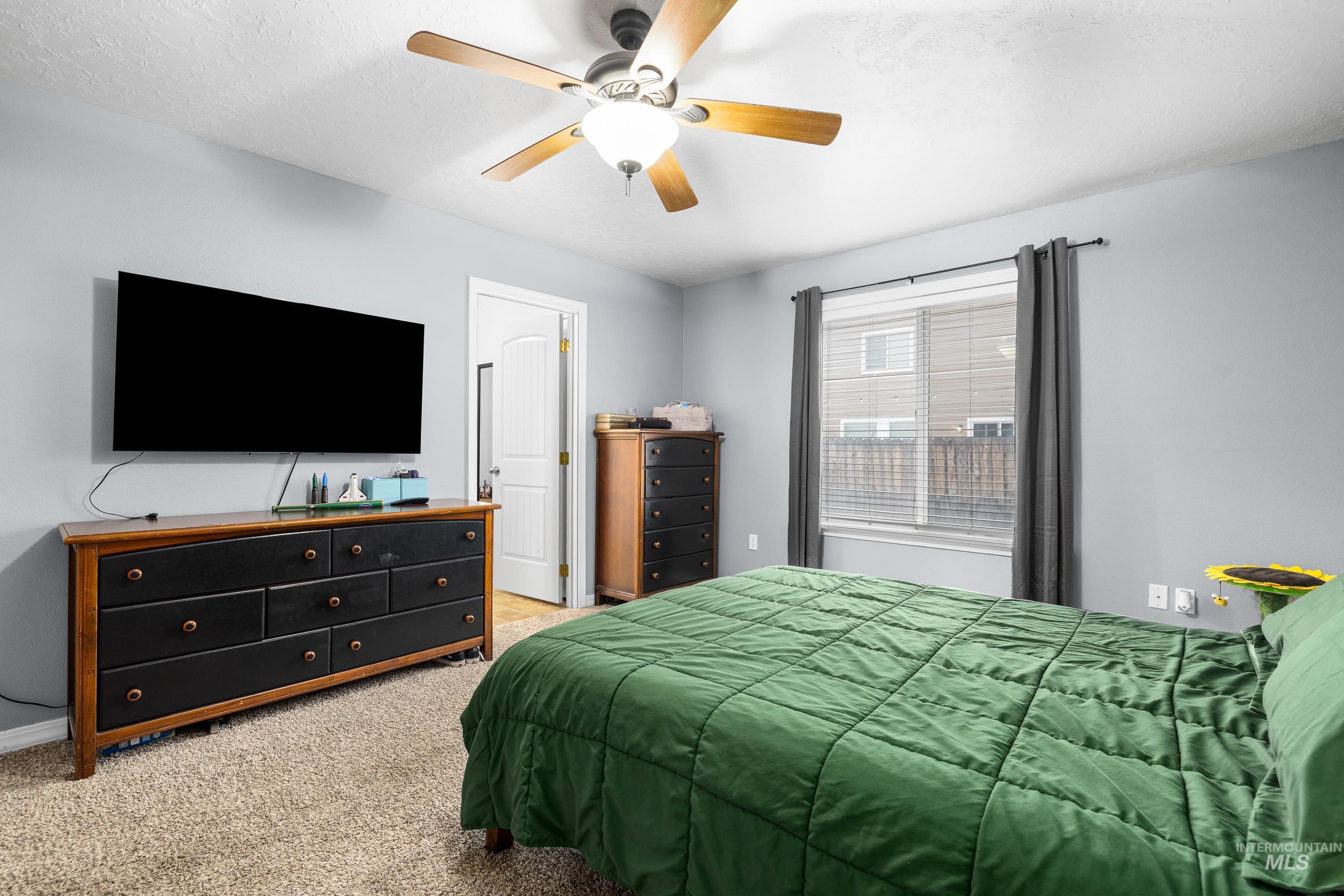 191 Southwest Quaker Drive Mountain Home, ID 83647 - Photo 24 of 43 Bedroom featuring light colored carpet, a ceiling fan, and a textured ceiling