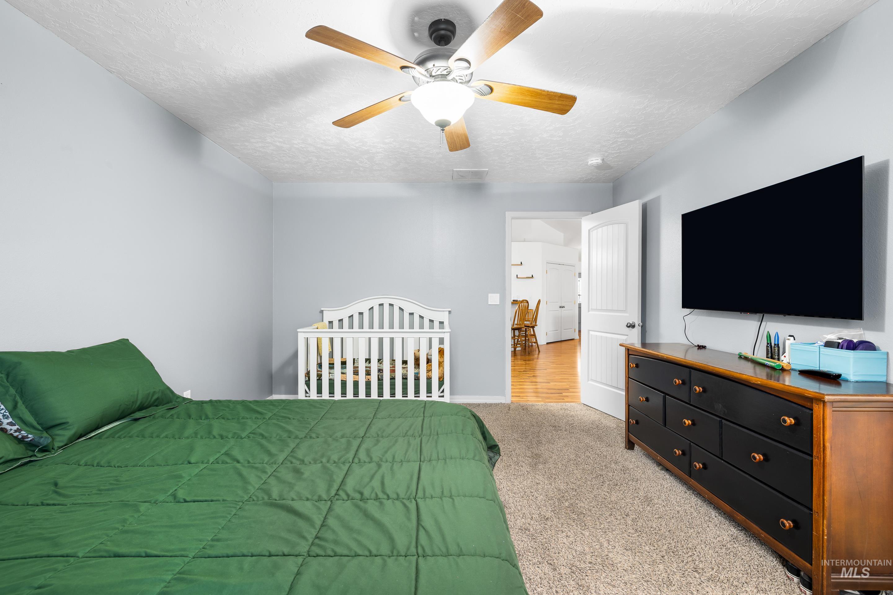 191 Southwest Quaker Drive Mountain Home, ID 83647 - Photo 25 of 43 Bedroom with carpet, ceiling fan, and a textured ceiling