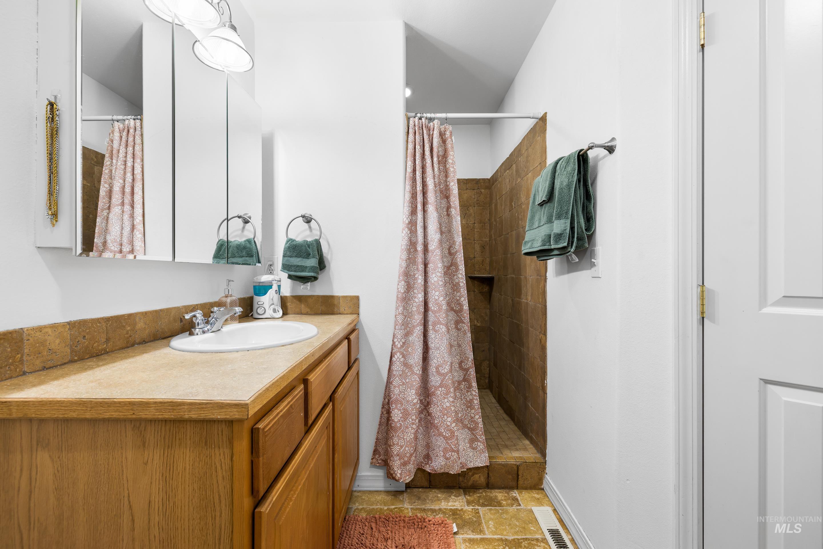 191 Southwest Quaker Drive Mountain Home, ID 83647 - Photo 26 of 43 Full bath with a stall shower, vanity, and stone finish flooring