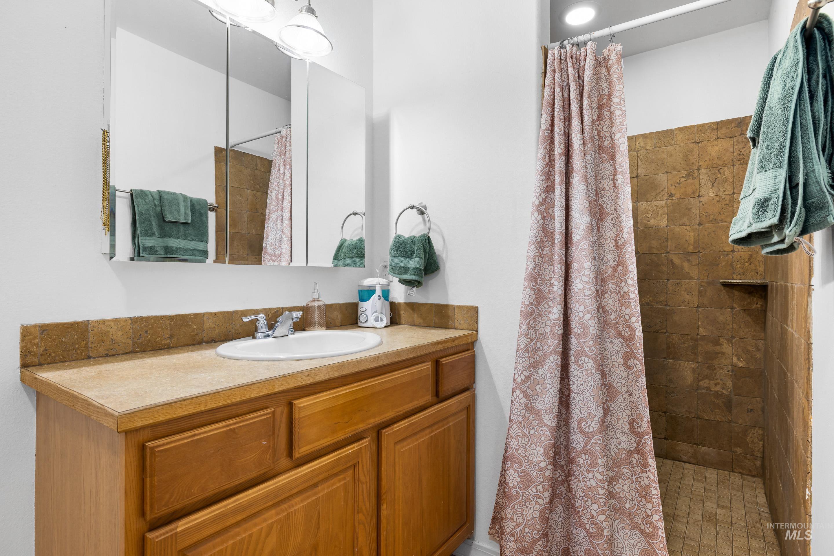 191 Southwest Quaker Drive Mountain Home, ID 83647 - Photo 27 of 43 Bathroom featuring tiled shower and vanity