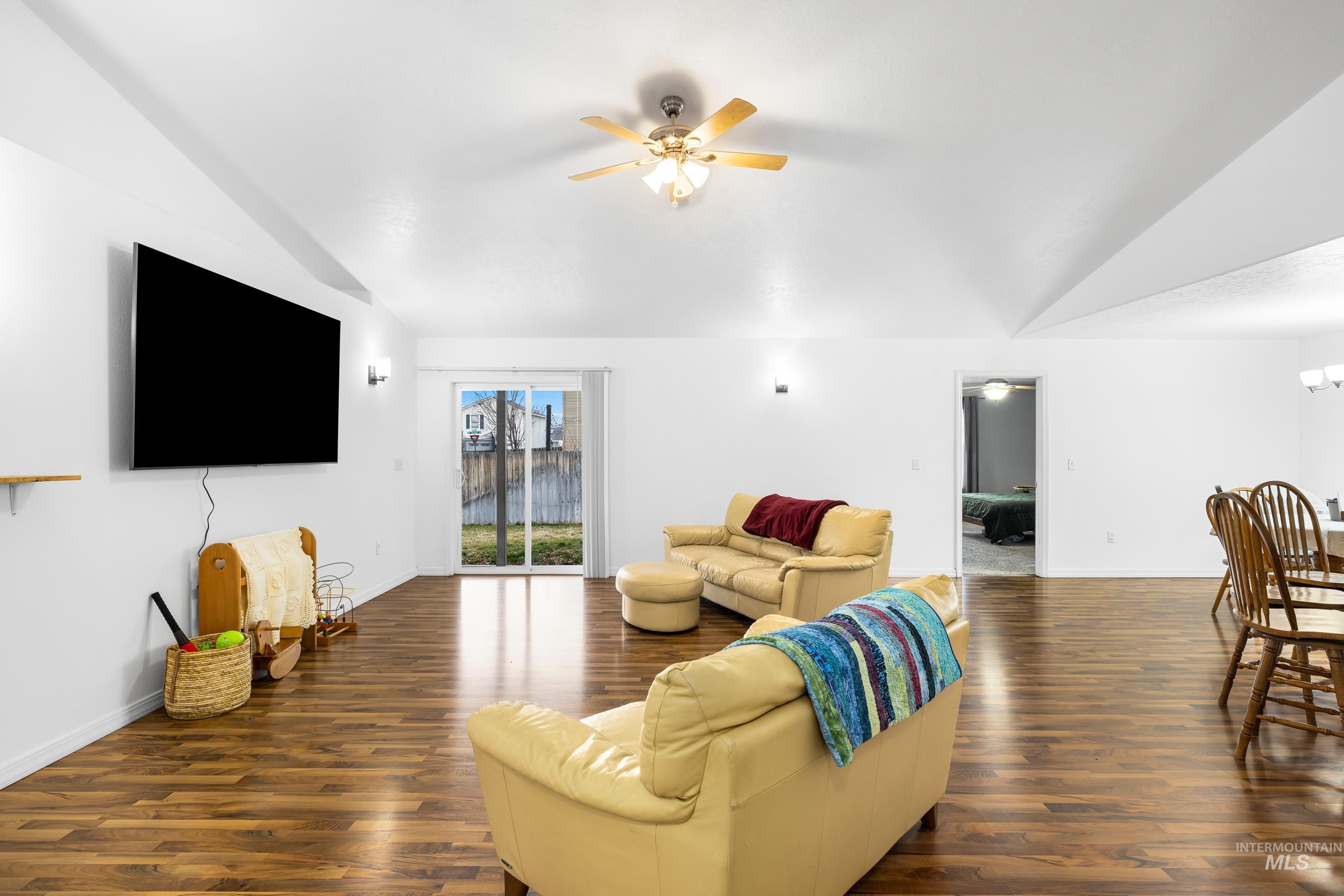 191 Southwest Quaker Drive Mountain Home, ID 83647 - Photo 7 of 43 Living room with lofted ceiling, ceiling fan, and dark wood finished floors