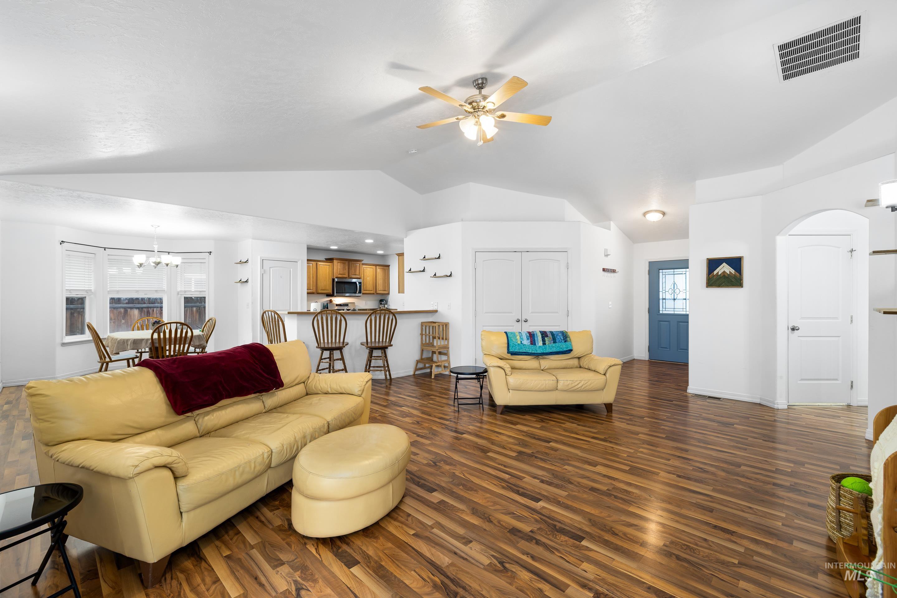 191 Southwest Quaker Drive Mountain Home, ID 83647 - Photo 9 of 43 Living room with dark wood-style floors, a chandelier, ceiling fan, and lofted ceiling