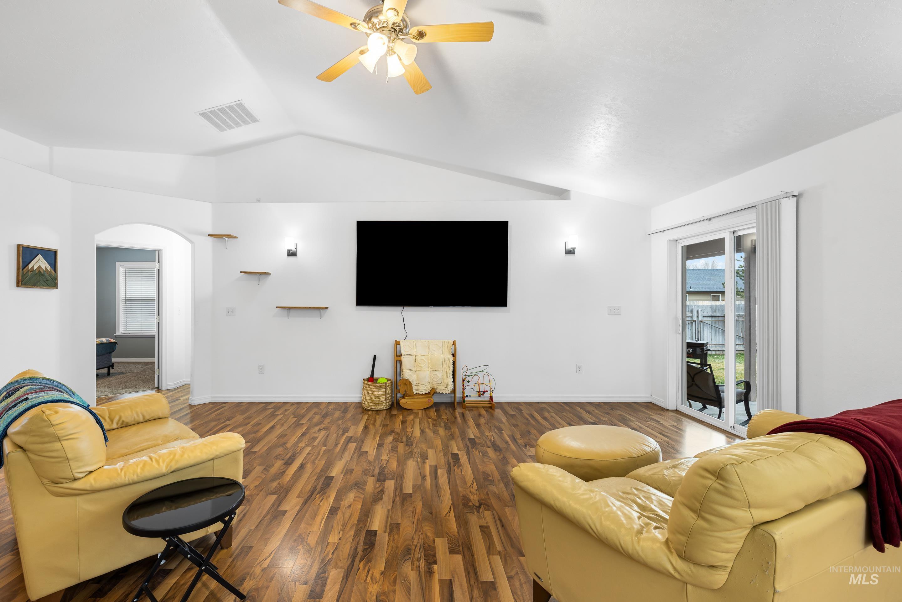 191 Southwest Quaker Drive Mountain Home, ID 83647 - Photo 10 of 43 Living room featuring wood finished floors, ceiling fan, lofted ceiling, and arched walkways