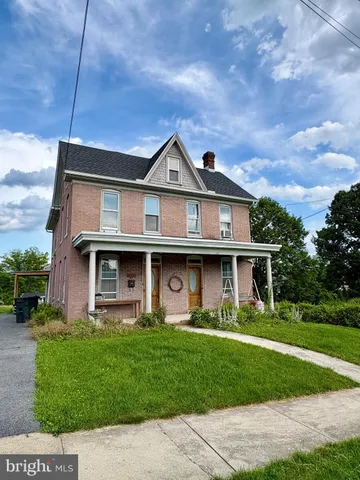 a front view of a house with a garden and plants