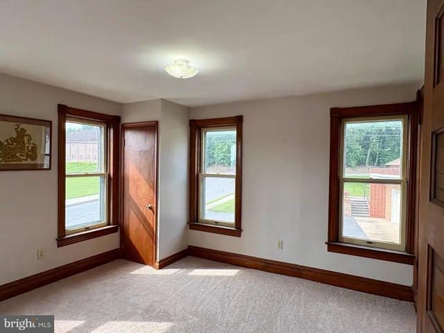 an empty room with windows and closet