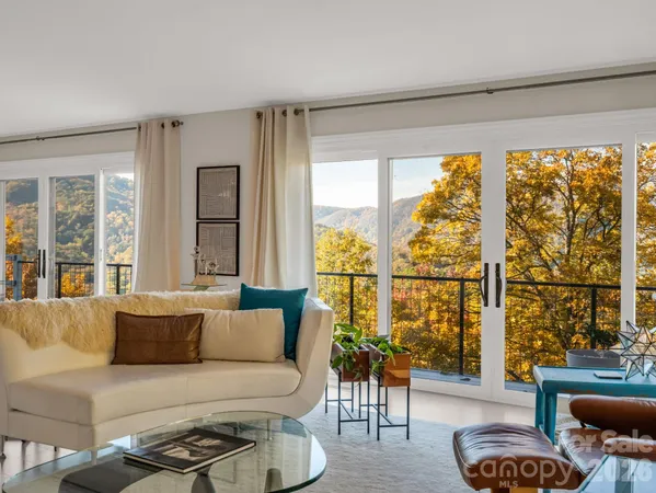 a living room with furniture and floor to ceiling windows