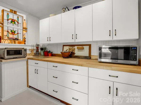 a kitchen with granite countertop white cabinets and stainless steel appliances