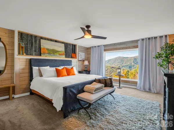 a spacious bedroom with a bed a couch and a potted plant