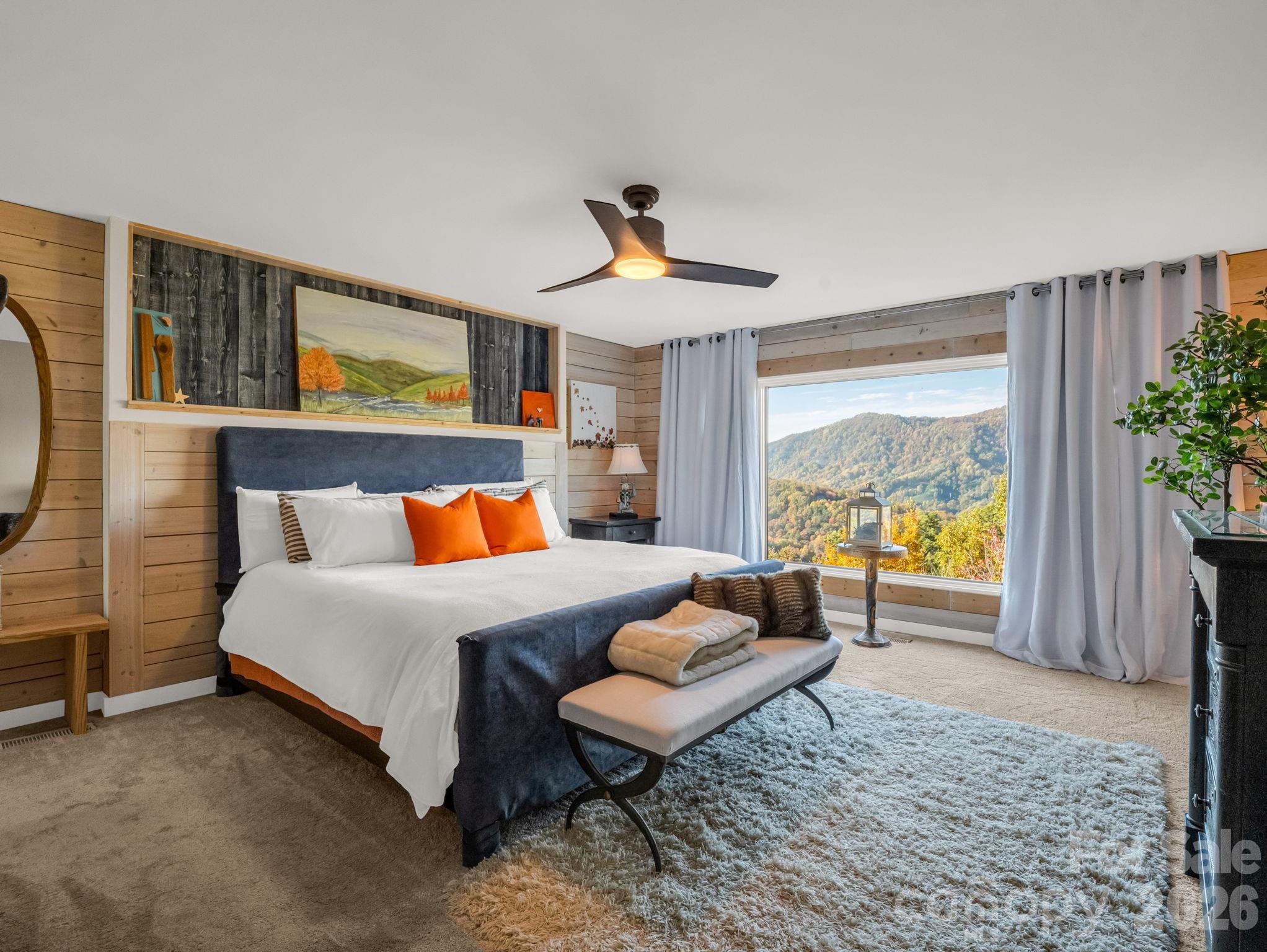 200 Piney Mountain Road Tryon, NC 28782 - Photo 23 of 48 a spacious bedroom with a bed a couch and a potted plant