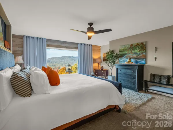 a bedroom with a large bed and a flat tv screen