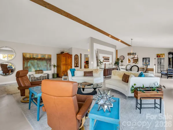 a living room with furniture a fireplace and large windows