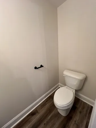 a white toilet sitting next to a wooden cabinet