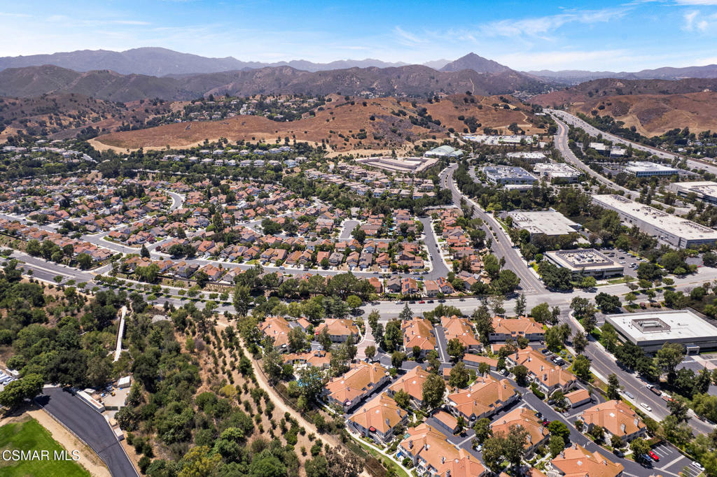 an aerial view of residential houses with outdoor space and trees