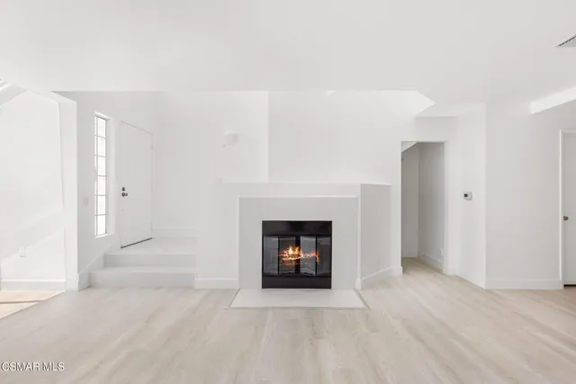 an empty room with wooden floor and fireplace