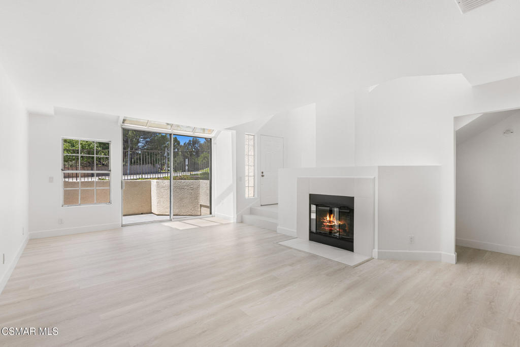 4240 Lost Hills Road, Unit 802 Calabasas, CA 91301 - Photo 26 of 49 an empty room with wooden floor and fireplace