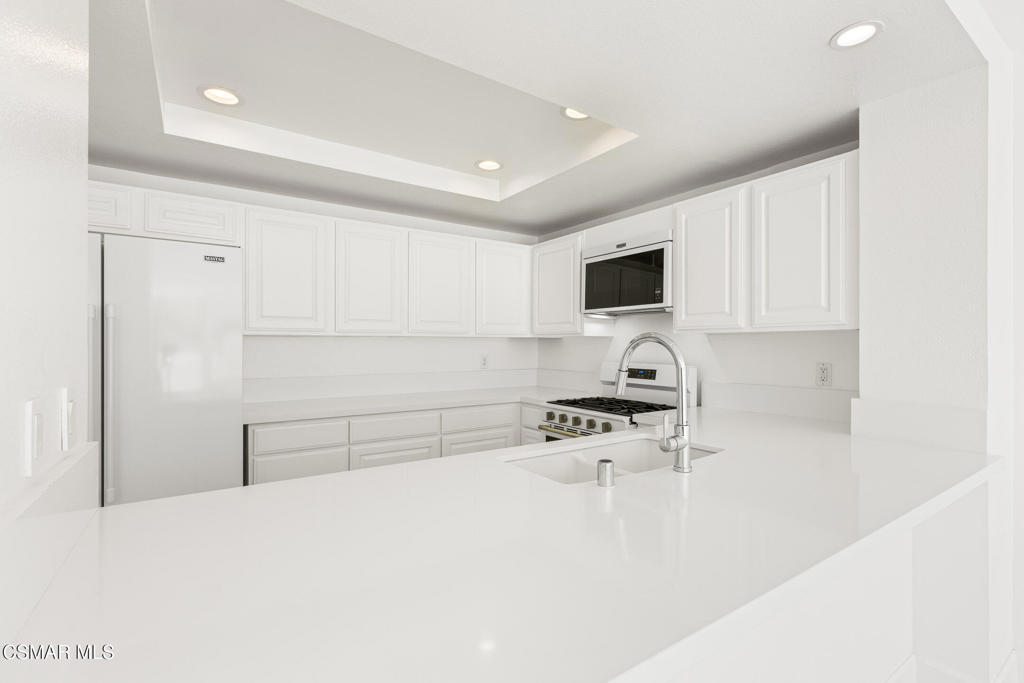 4240 Lost Hills Road, Unit 802 Calabasas, CA 91301 - Photo 31 of 49 a kitchen with stainless steel appliances a stove a refrigerator a sink a white counter space and cabinets
